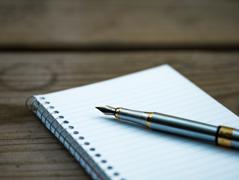 Photo of a pen sitting on top of a journal
