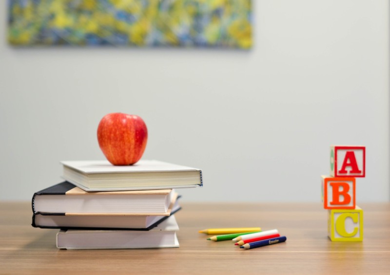 Photo of a school desk with supplies sitting on top of it