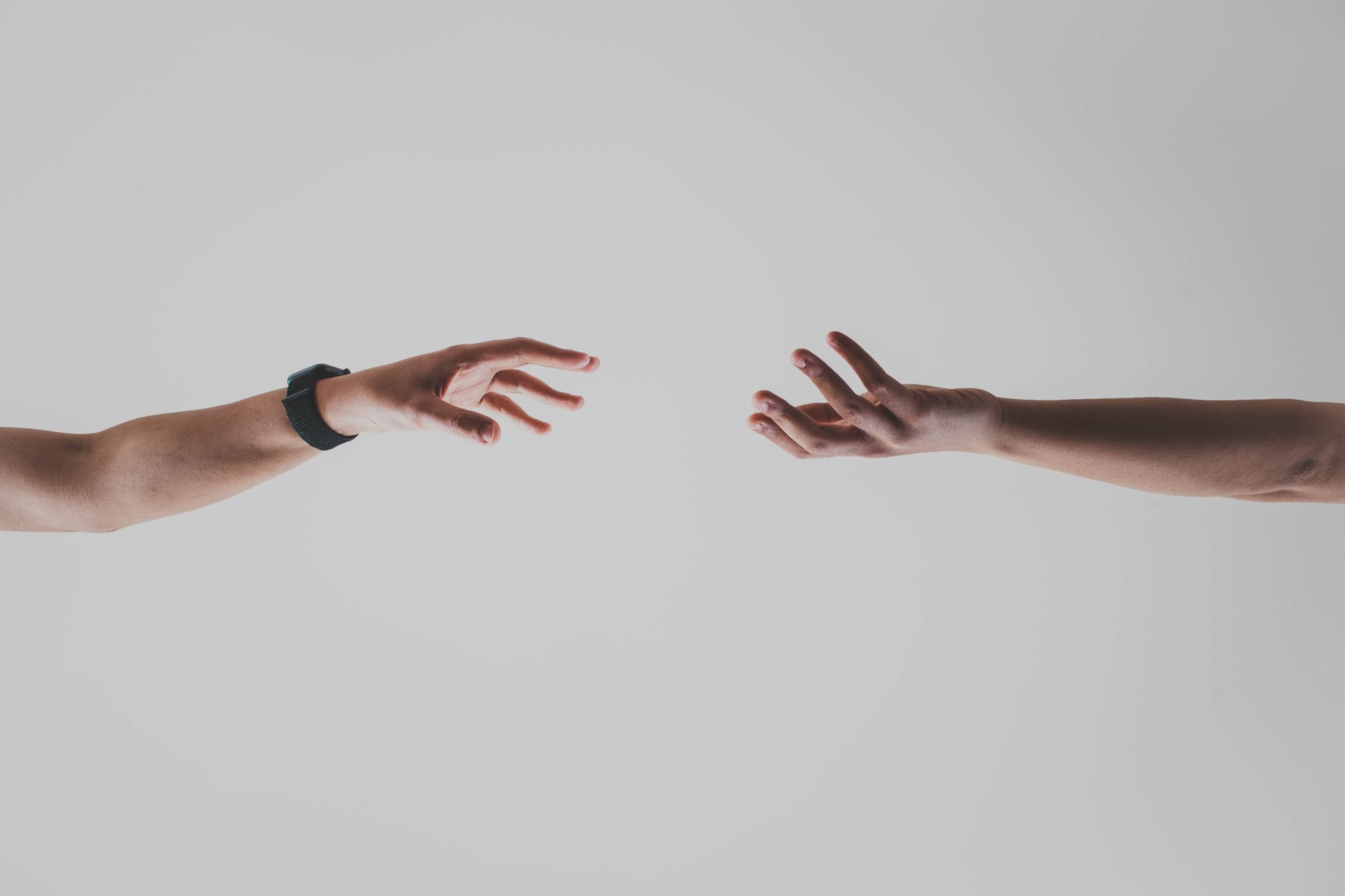 Photo of two hands reaching out to each other but there is distance between them.
