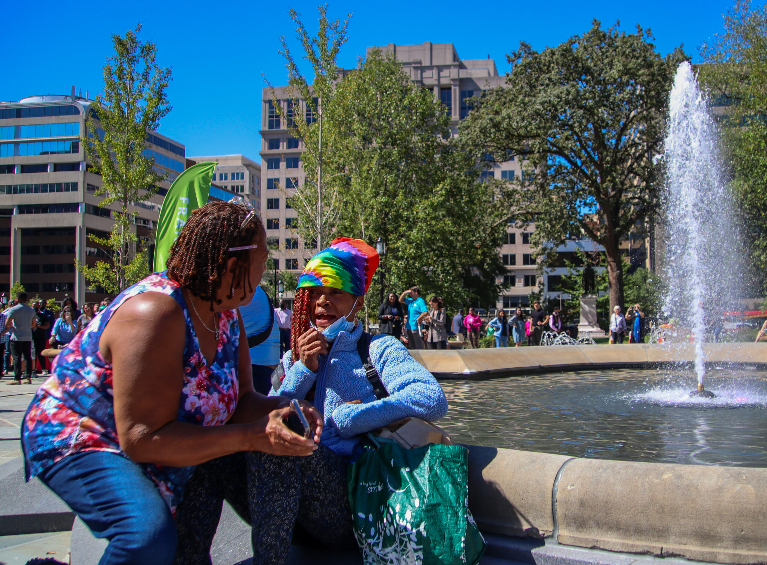A housed resident speaks with Chandra Brown, a homeless woman that interrupted Mayor Bowser's Franklin Park press conference.