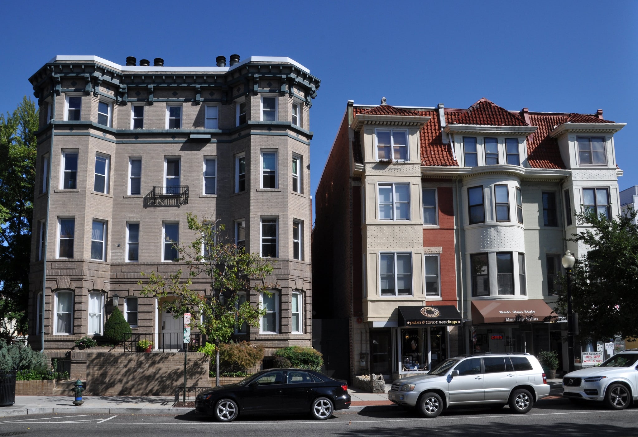 Two buildings stand next to each other on the side of the road.