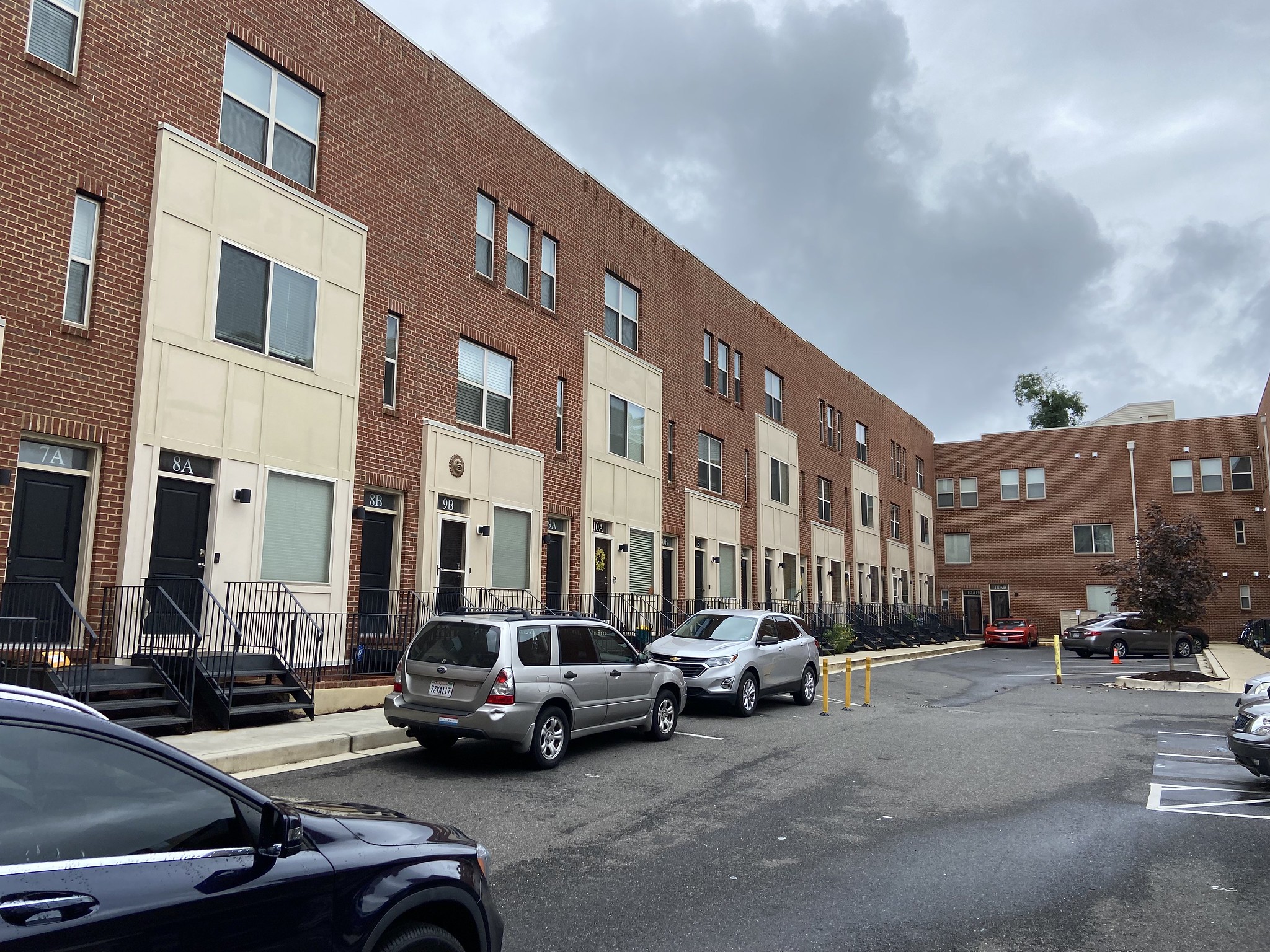 A street view of Talbert Street Townhomes. Multiple cars are parked along the side of the street.