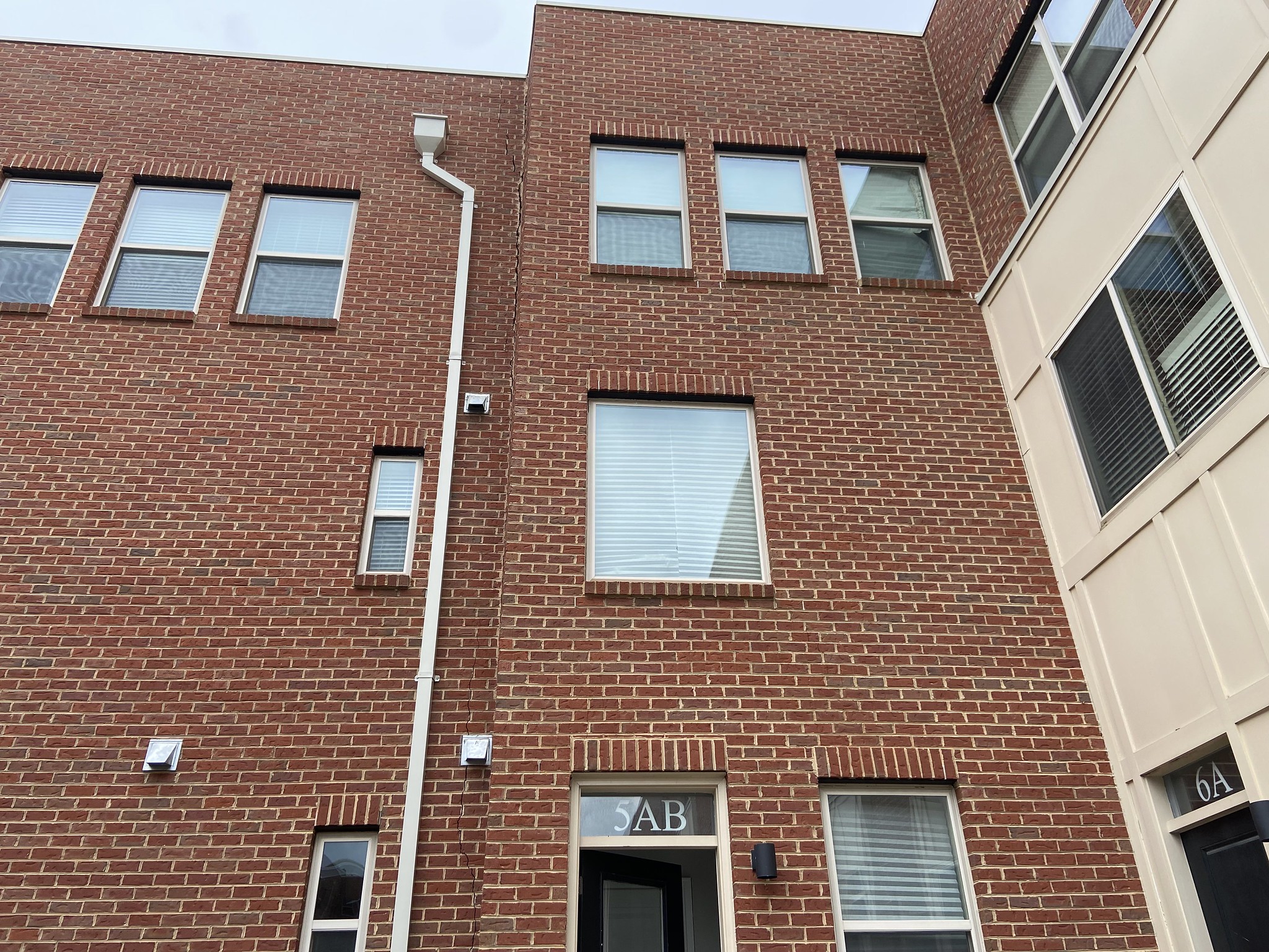 A large crack runs down the exterior wall of a building.