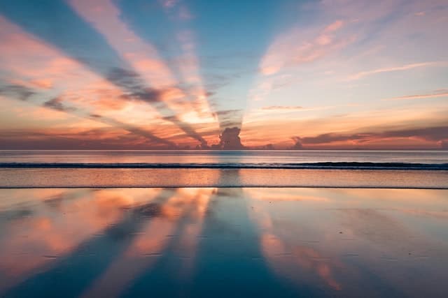 Photo of a blue and pink sunset behind a cloud.