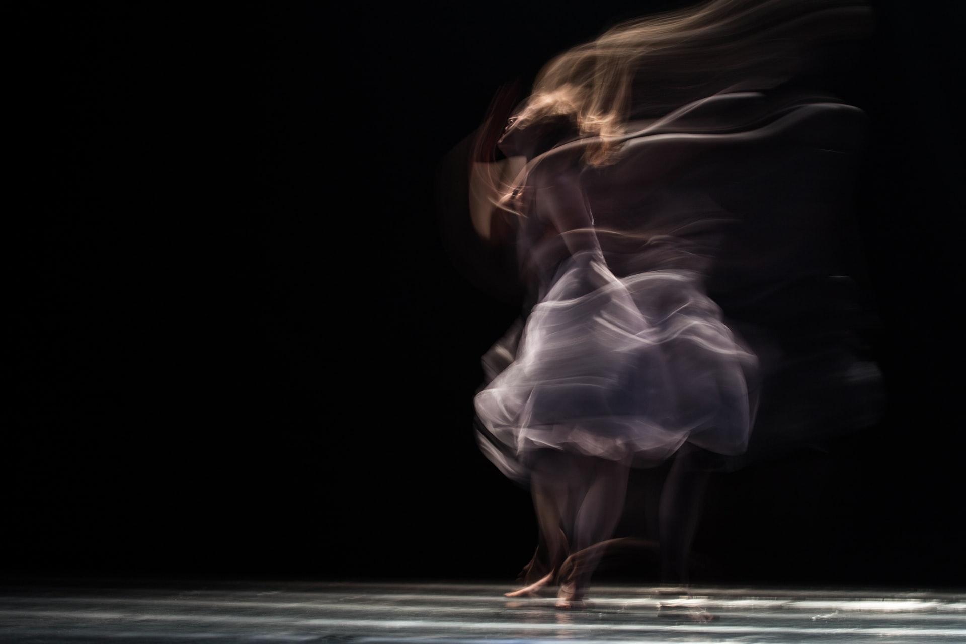 A photo of someone spinning with light trails following them