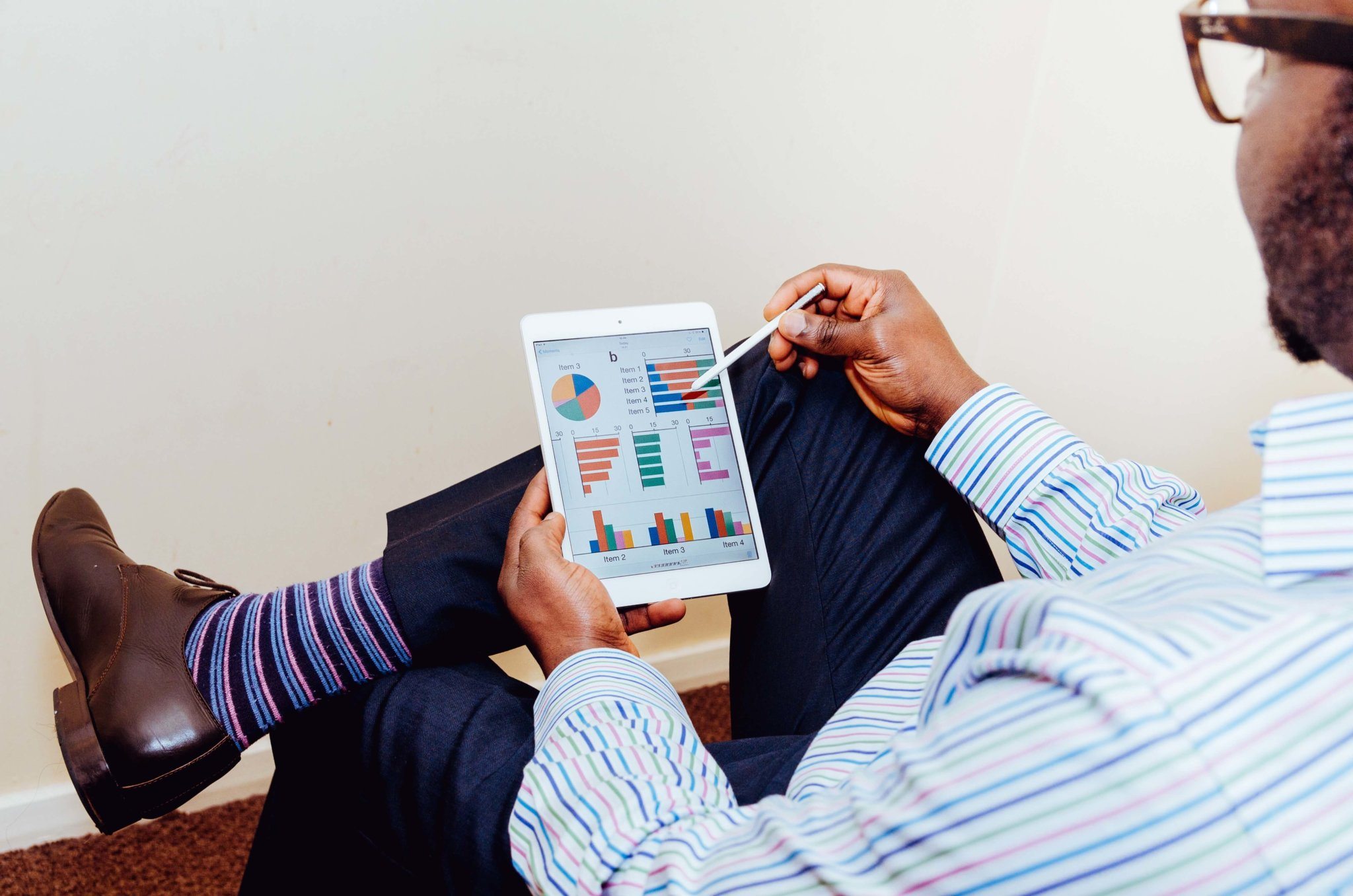 A man reclines while using an IPad.