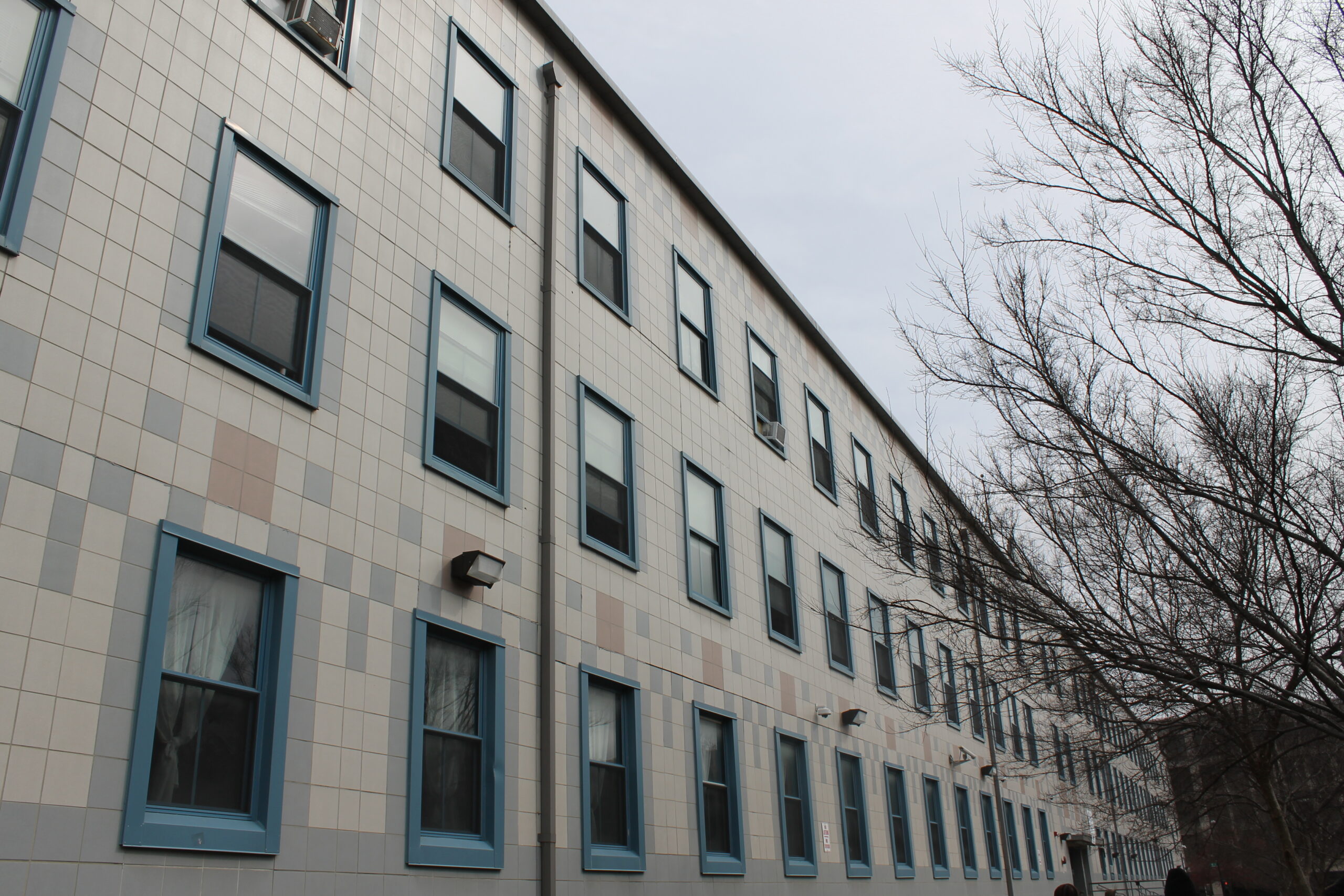 A white building with blue window frames on a bleak day.