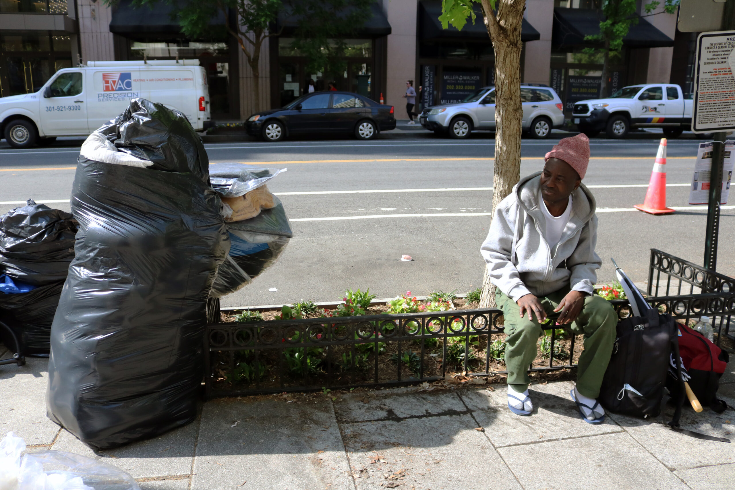 Gigi Dovonou sitting on a fence on G Street, waiting for the encampment closure to begin. Photo by Athiyah Azeem