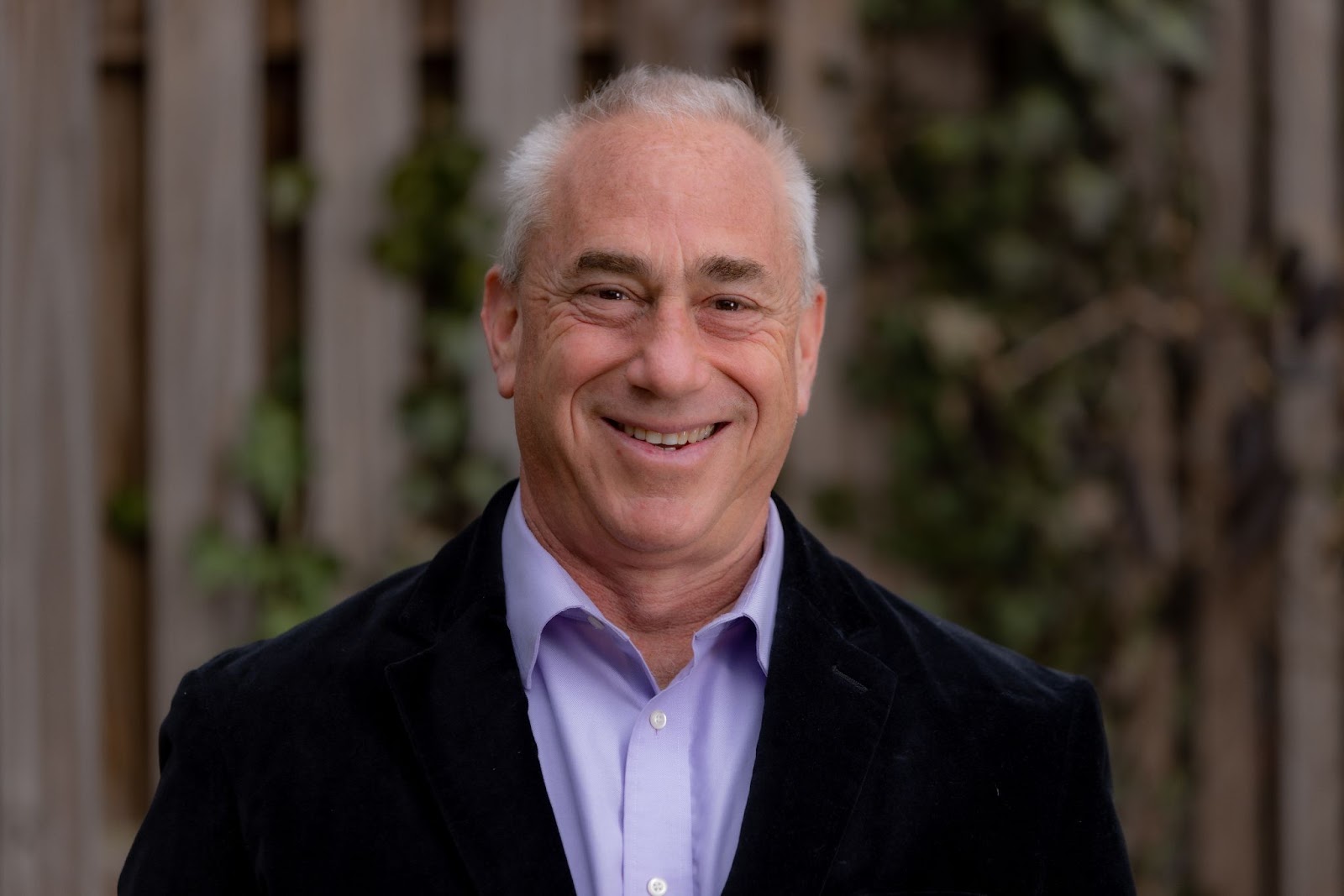 A smiling white man in a suit.