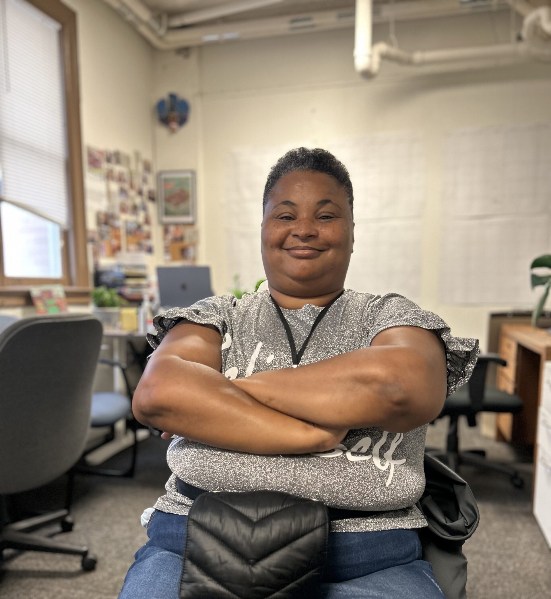 A Black woman leans back in a chair, smiling.