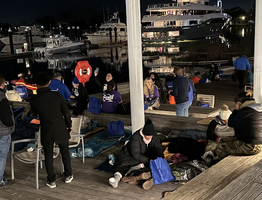 A group of people set up sleeping bags near the Wharf.