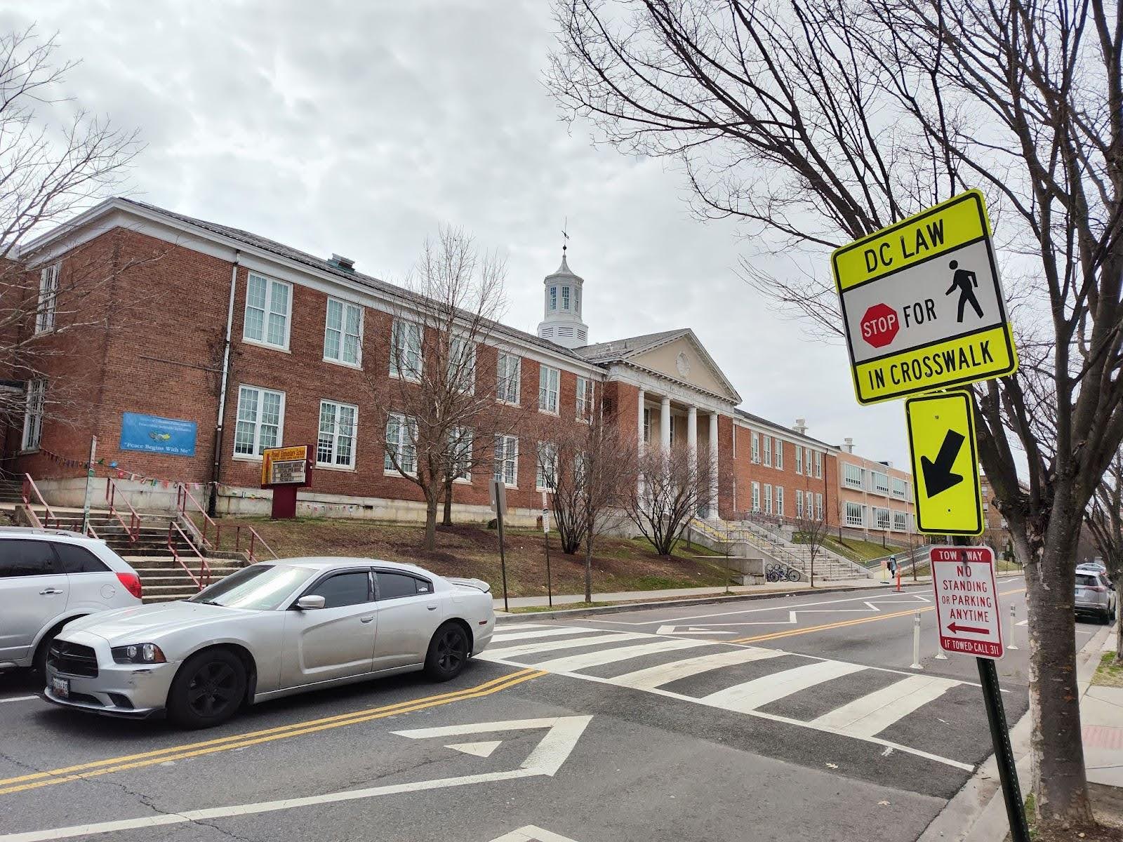 A large brick school sits across the street.
