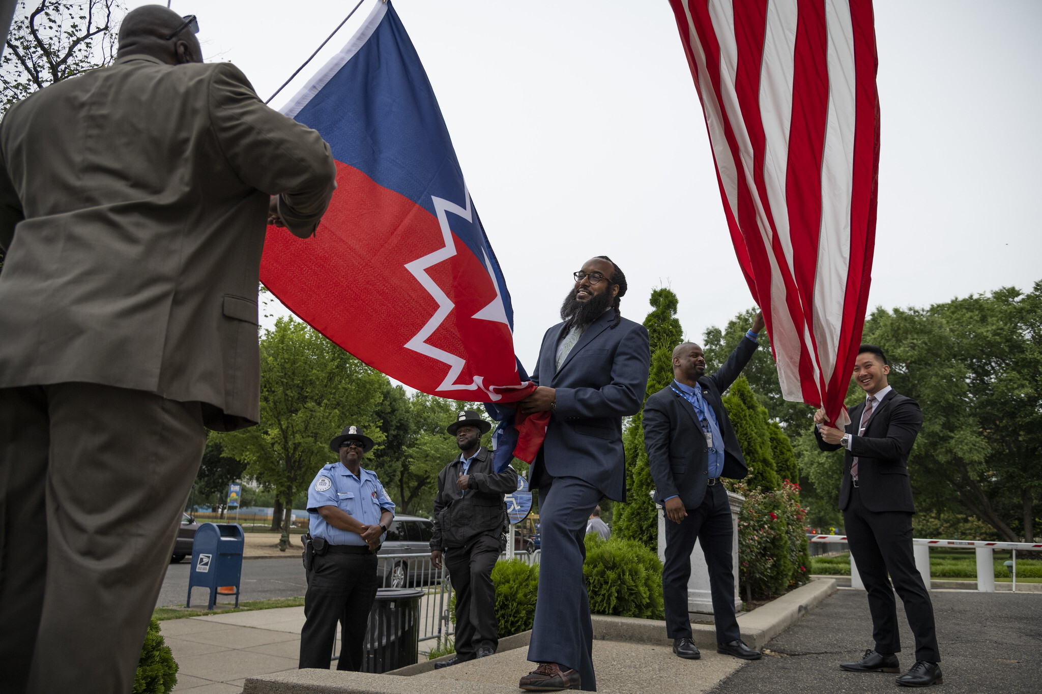 Four people hold an American and Juneteenth flag.