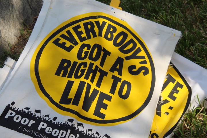 A yellow sign reads "Everybody's got a right to live."