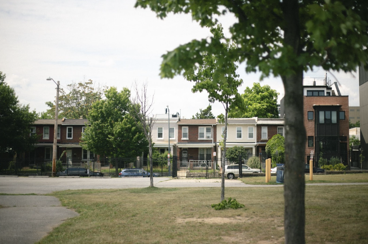 Photo of a basketball court in front of four buildings.