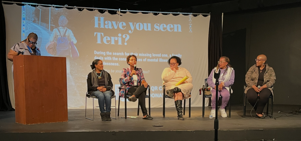 Five Black women sit in chairs in from of a screen reading "Have you seen Teri?"