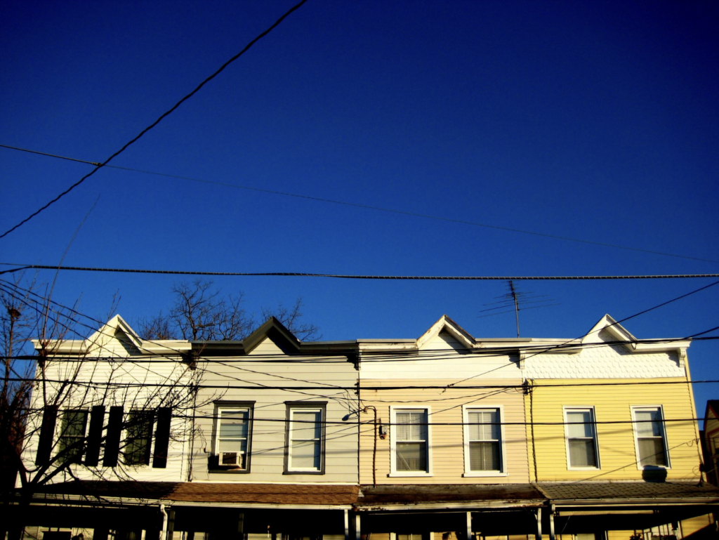 Families have relied on Rapid Rehousing to stay in the city. Line of houses with blue sky.
