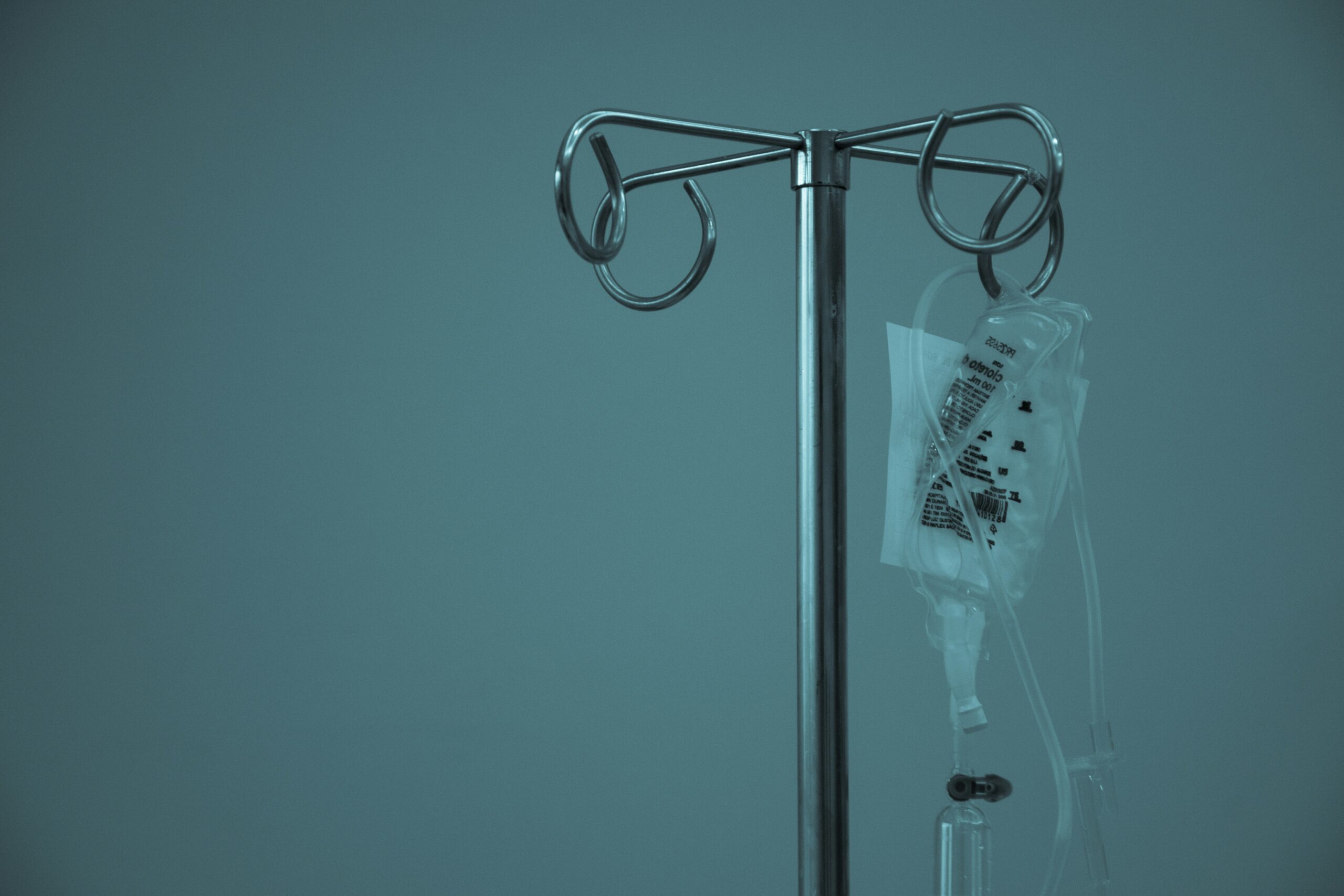 An IV machine in front of a blue wall.