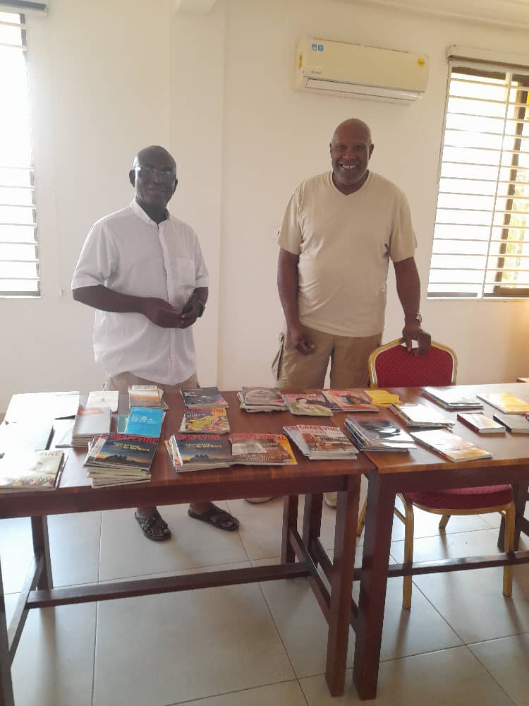 Wendell (right) and his counterpart in Ghana with the books. Photo courtesy of Wendell Williams